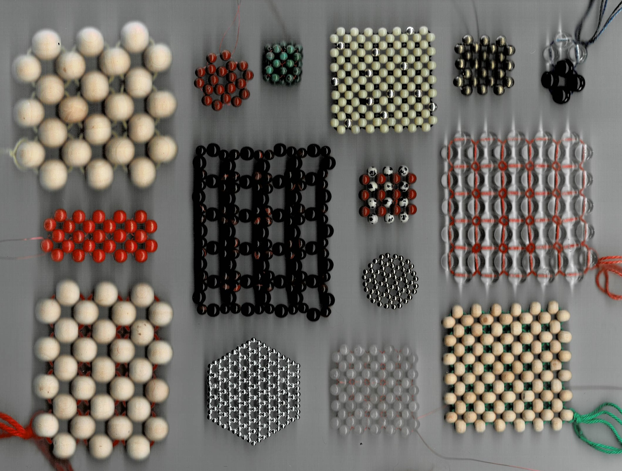 a scanned image of multiple beaded swatches of different sizes and materials: Glass, stone, metal, wood, cotton, wool, red enameled copper wire