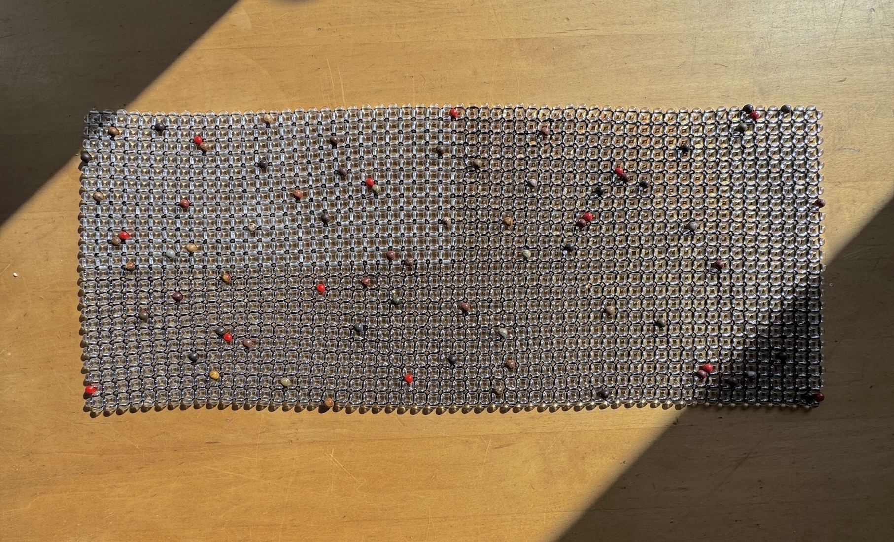 glass beaded fabric laying on wooden table
